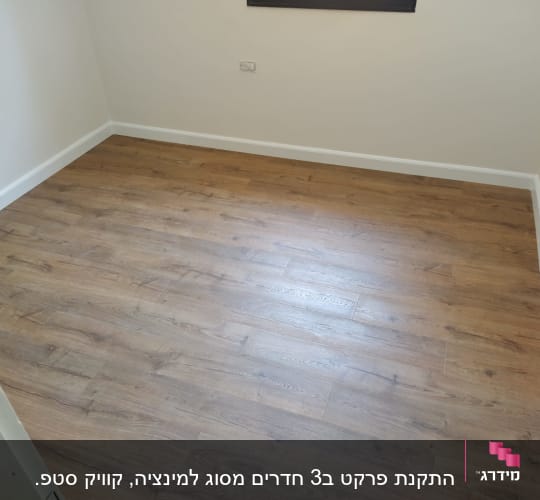 רצפת פרקט עץ בחדר ריק עם קירות לבנים